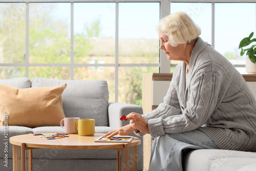 Senior woman with dementia doing puzzle at home