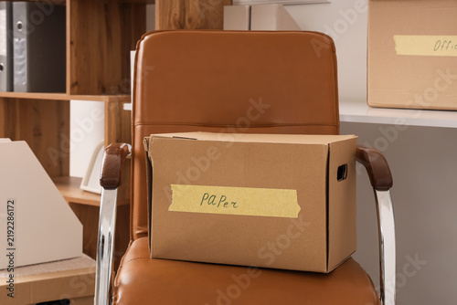 Konstfotografi Corporate downsizing and unemployment cardboard box on office chair job loss lay