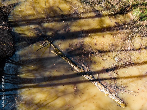 Fotografía Aerial view of a muddy gully filled with stagnant spring floodwater, featuring a