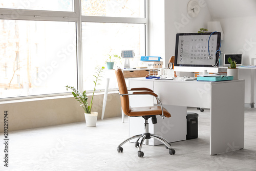 Computer monitor with calendar and doctors supplies on desk in medical office