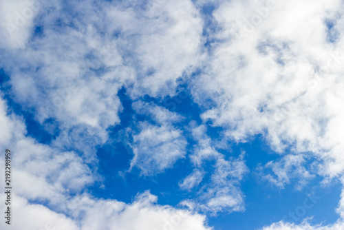 Foto Fluffy white cumulus clouds drifting across a bright azure sky, creating a peace