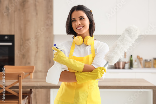 Female janitor with pp-duster and detergent in kitchen
