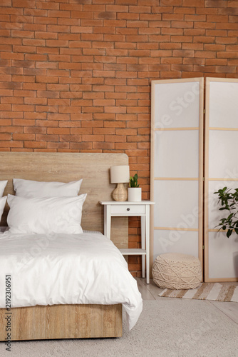 Quadro su tela Interior of light bedroom with cozy bed and white folding screen