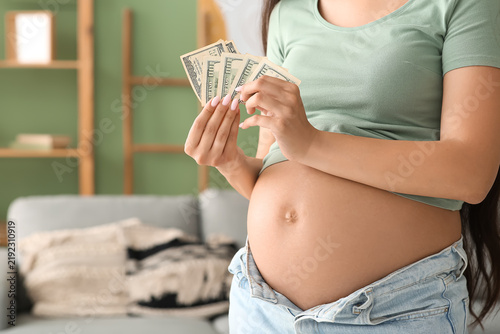 Konstfotografi Young pregnant woman with money at home, closeup