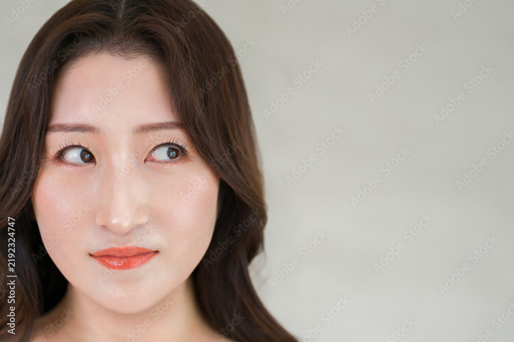 Fototapeta premium 透明感のある美肌と目元が印象的な若い女性。アイケアと美容のイメージ