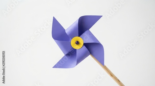 Purple paper pinwheel toy on a wooden stick isolated on white background