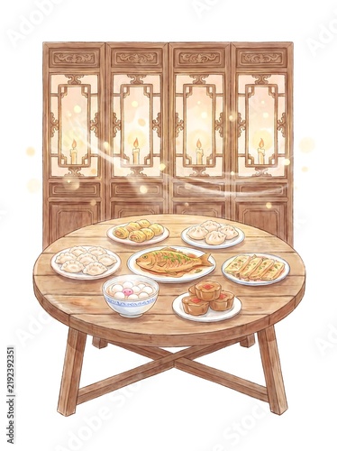 Round wooden table set with a festive New Year meal by a screen