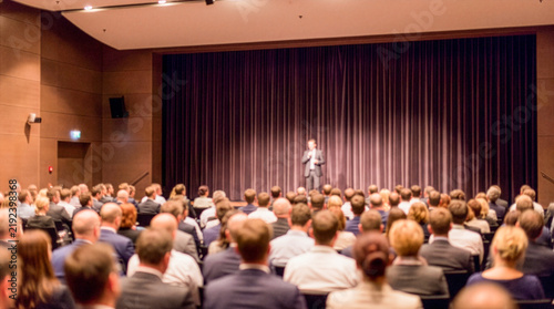 Blurred audience watching speaker on stage at business conference
