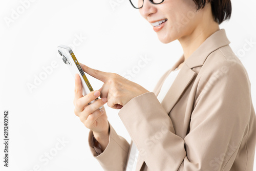 Фотография スマトフォンを使う眼鏡をかけたスーツ姿の女性