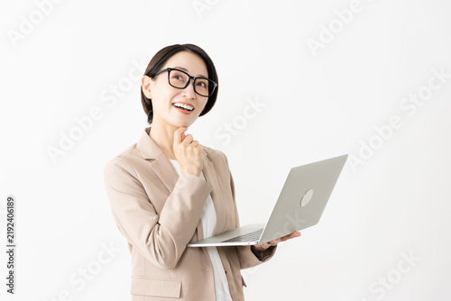 Fotografie ノートパソコンを使う眼鏡をかけたスーツ姿の女性