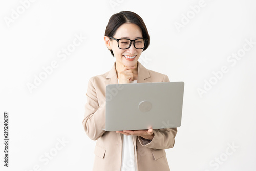Fotografie ノートパソコンを使う眼鏡をかけたスーツ姿の女性