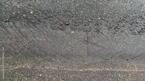Shallow Rainwater Runoff on Wet Asphalt with Raindrop Ripples