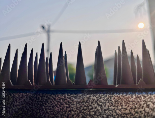 Принти на полотні Security spikes silhouetted against the setting sun.
