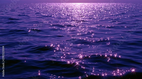 Sparkling purple ocean water surface at sunset with vibrant light reflections