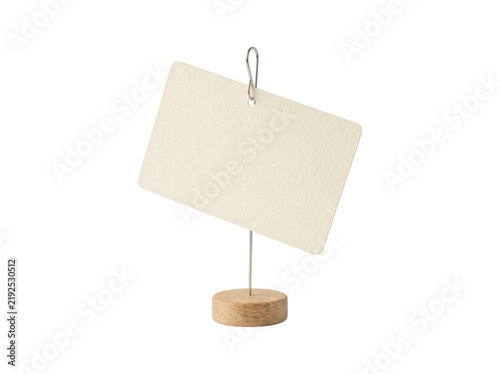 фотографія Cream paper card held by silver wire clip on small wooden pedestal isolated on t