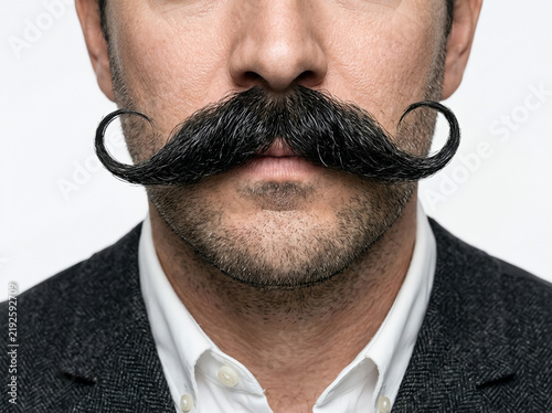 Closeup of a man with a perfectly groomed handlebar mustache isolated on white background
