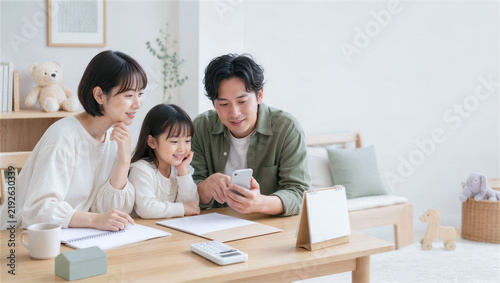 Plakat スマートフォンとノートで家計を確認する家族