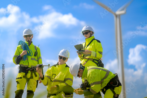 Foto Female wind technician looks down at the drone in a colleague's hands while the
