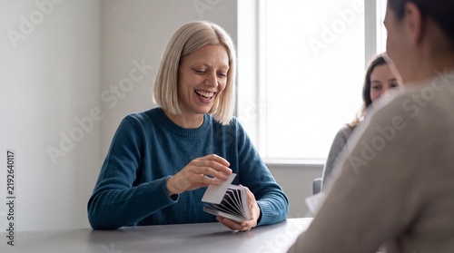 Freunde spielen lachend Kartenspiel bei geselligem Treffen