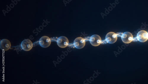 Chain of glowing translucent spheres linked by particle thread for blockchain ledger sequence data linkage and connected node concept