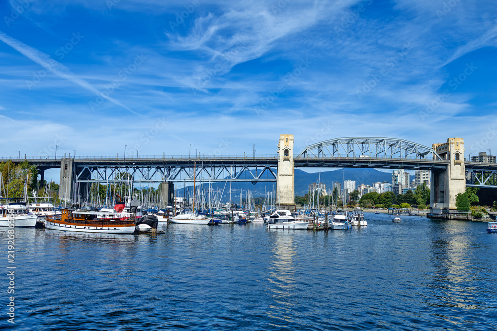 Fototapeta premium Burrard Bridge spans over a busy marina filled with sailboats and yachts, Granville Island,Aquabus Ferry Dock, Vamcouver, BC, Canada 