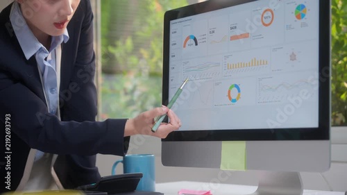 Businesswoman analyzing company financial data and growth chart on a computer dashboard screen in the office