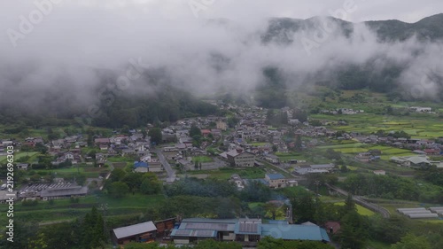 Aerial view of low clouds and green fields in small mountain village - Nagano, Japan