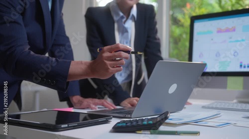 Business colleagues collaborating on a financial data analysis project and reviewing company performance on a laptop screen