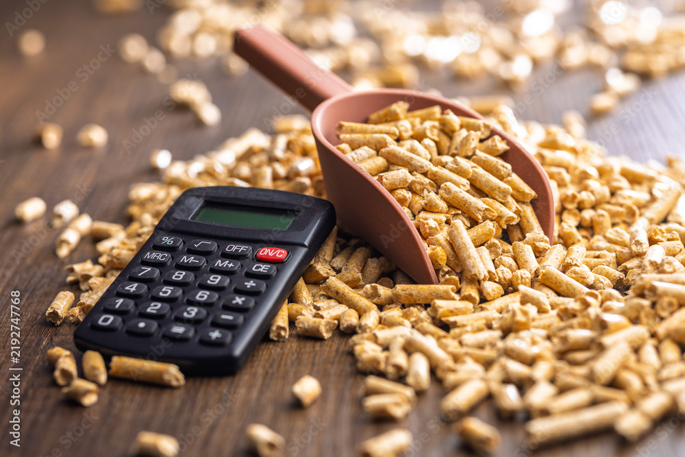 Obraz premium Wood Pellet Fuel Scoop With Calculator for Energy Cost Calculation and Biomass Heating Budgeting