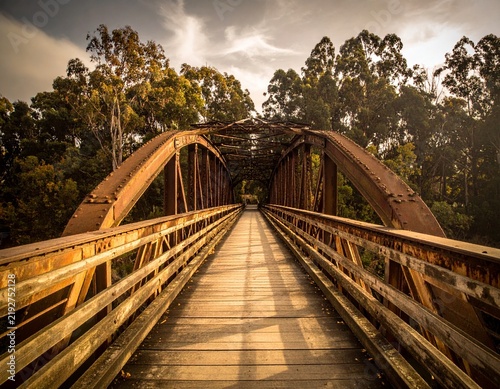 Rustic wooden bridge crossing a peaceful natural landscape, symbolizing adventure, connection, travel, and traditional craftsmanship.