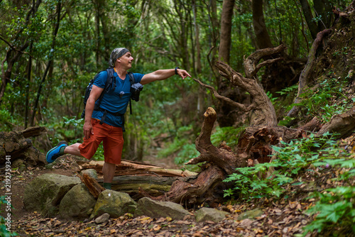 Plakat Hiker posing with fallen tree trunk