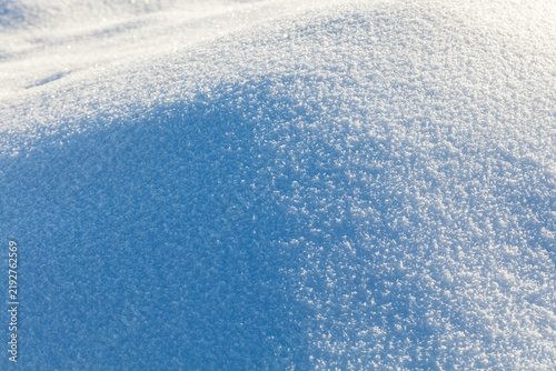 Принти на полотні Soft snow blankets gentle hillside with crisp, blue-tinged shadows