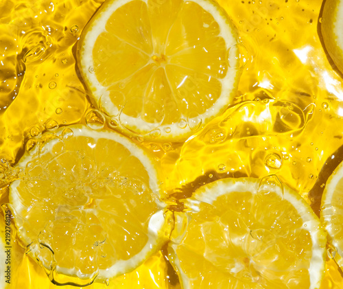 Refreshing citrus composition with sliced lemons floating in transparent water
