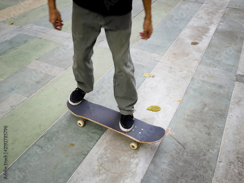 Quadro su tela A male skateboarder with a black shirt doing a kickflip on a skateboard on a clo