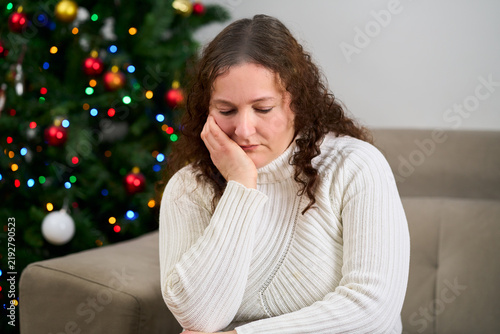 Sad, couch and woman in home on christmas with crying for depression, loneliness or hopeless. Mental health, holidays and person with tears and emotions for alone on xmas in living room at apartment.