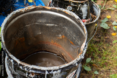 Cuadro en lienzo Old rusty metal bucket filled with stagnant dirty water outdoors on grass