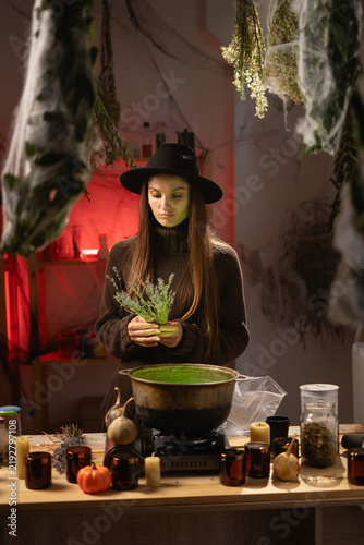 Fotografie A realistic witch brewing a potion in a cauldron