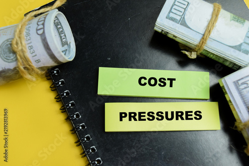 Concept of cost pressures write on sticky notes isolated on table. For financial inflation and budget stress