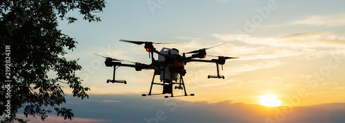 Agricultural technology smart farm concept. Farmer technicians remotely fly agricultural drones to fly to spray fertilizer in fields.