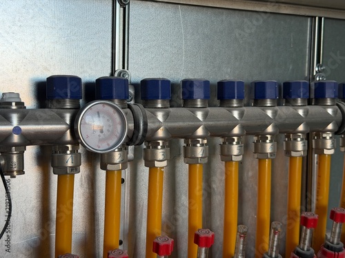 Quadro su tela Heating manifold with brass valves and blue caps, pressure gauge and yellow flex