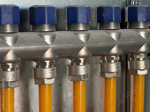 Canvastavla Heating manifold connections distributing warm water through yellow pipes and bl