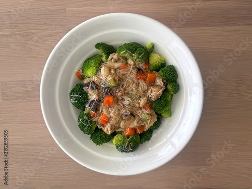 Quadro su tela Stir-fried broccoli with crab meat sauce in a white ceramic bowl on a wooden table, healthy Chinese food style