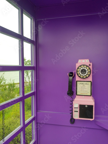 Quadro su tela Vintage wall mounted telephone inside a purple phone booth