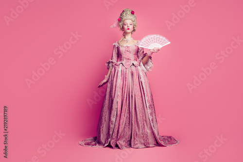 Full length photo of gorgeous pretty lady dressed pompous rococo costume rising hand fan empty space isolated pink color background