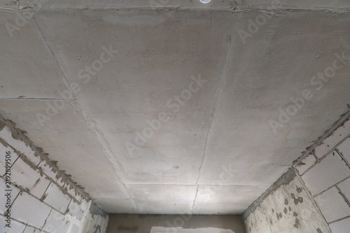Finished ceiling in a newly constructed room showcases smooth texture and lighting