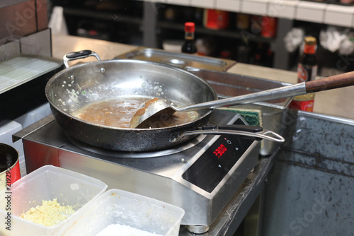 Poêle dans une cuisine professionnelle avec différentes préparations