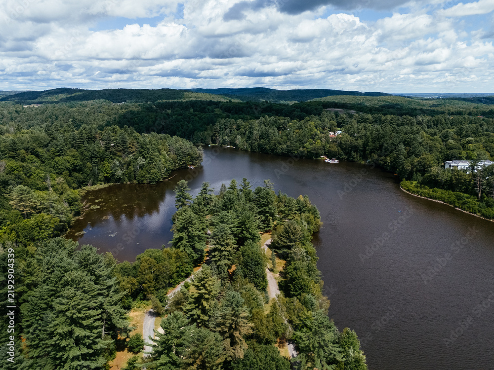 Fototapeta premium Aerial view of a scenic waterway with forested islands and lush green landscape in Rawdon, Quebec, Canada