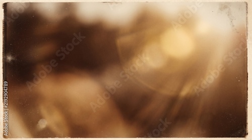 Vintage abstract sepia background with old film grain frame and light leak effect