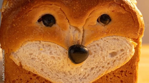 Shiba Inu dog shaped sourdough bread loaf on wooden table.