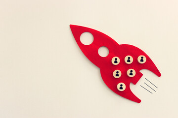 Wooden cubes with people icons forming rocket. Idea of leadership and teamwork